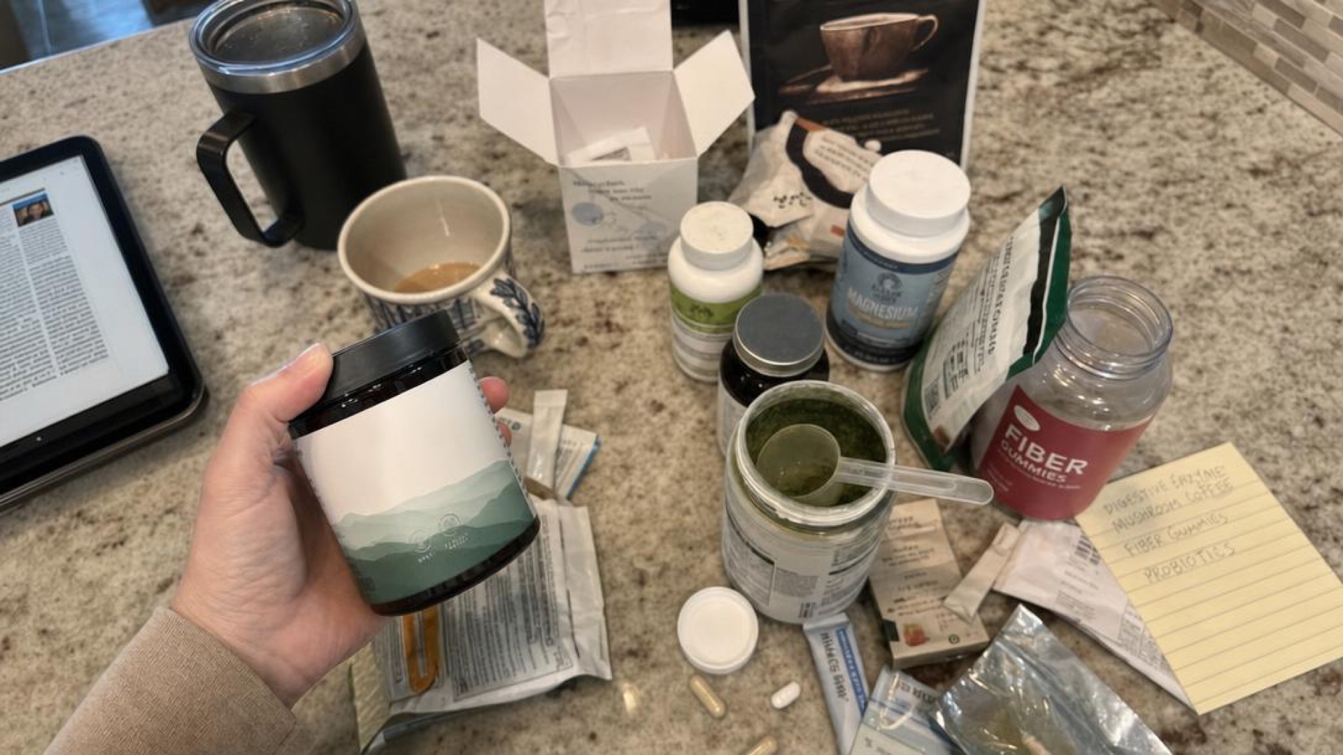 Handheld iPhone photo of many opened gut health products on a kitchen counter